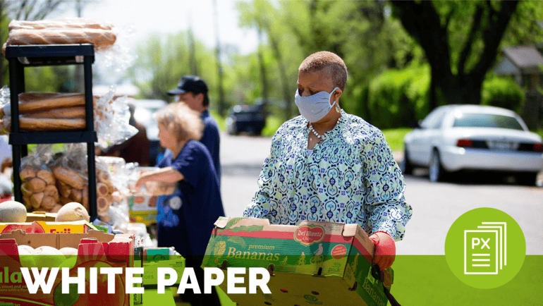 a woman wearing a mask carries a cardboard box of bananas at a food drive, meant to represent essential hospital; text at the bottom of the image reads white paper