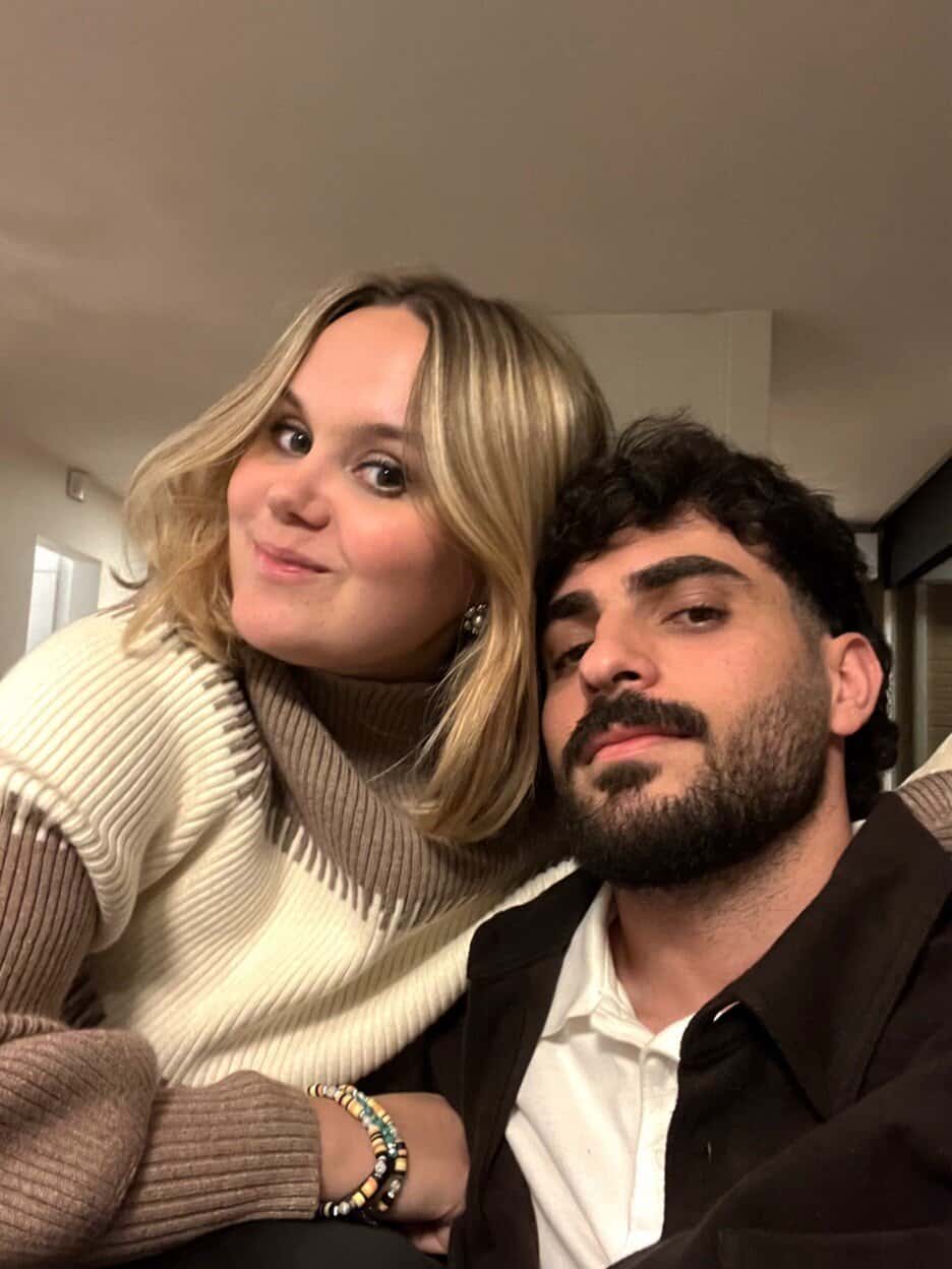 a young man and woman pose for a photo together