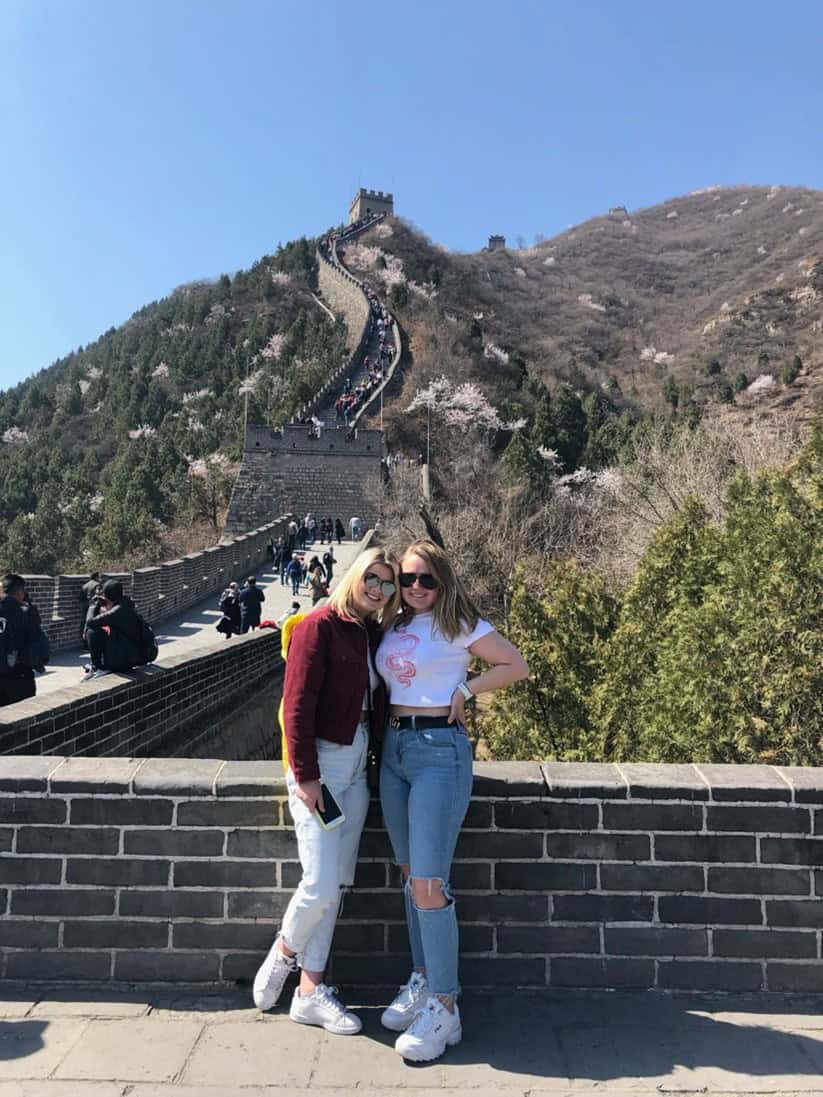 two women pose for a photo on the great wall of china
