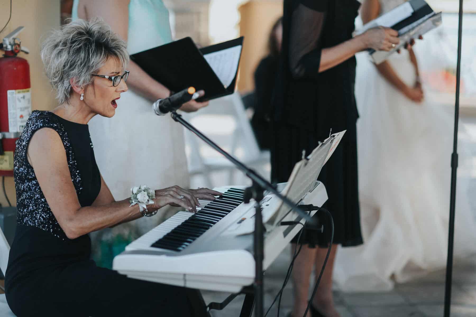 an image of a woman singing and playing the piano
